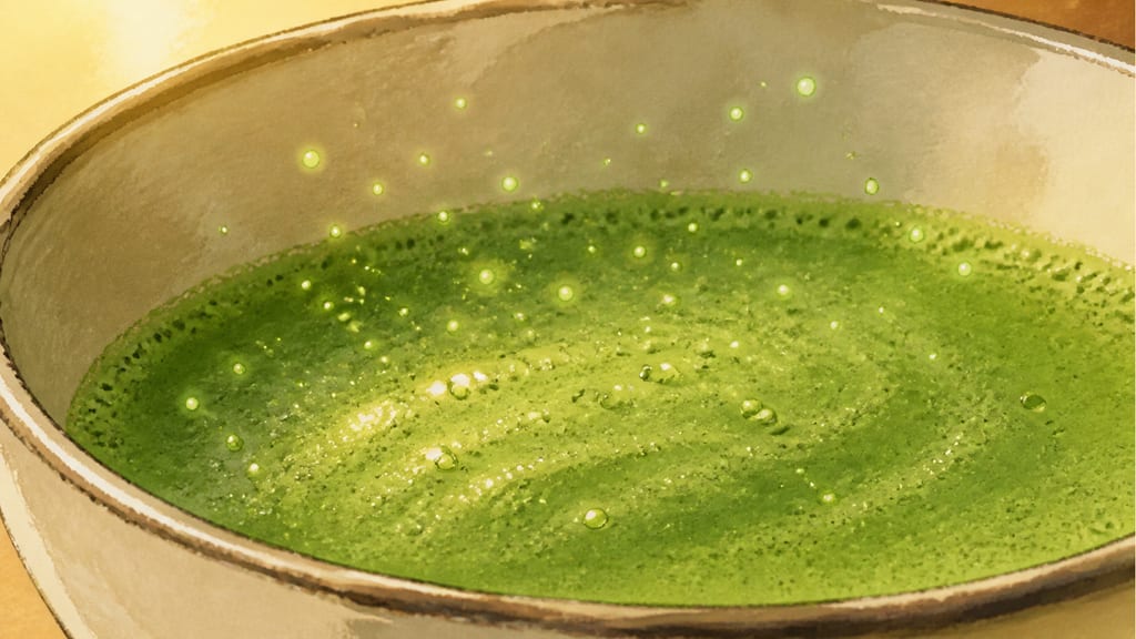 Macro: green sparkling motes settling onto matcha foam, the surface beginning to shiver